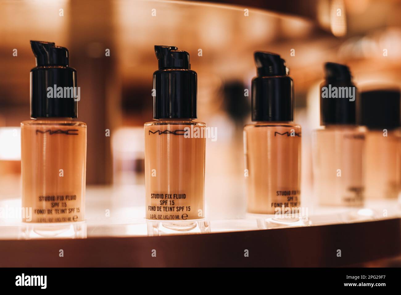 Glass tubes of Mac beige foundation on a stand in a store. The concept of decorative cosmetics for the face. Stock Photo