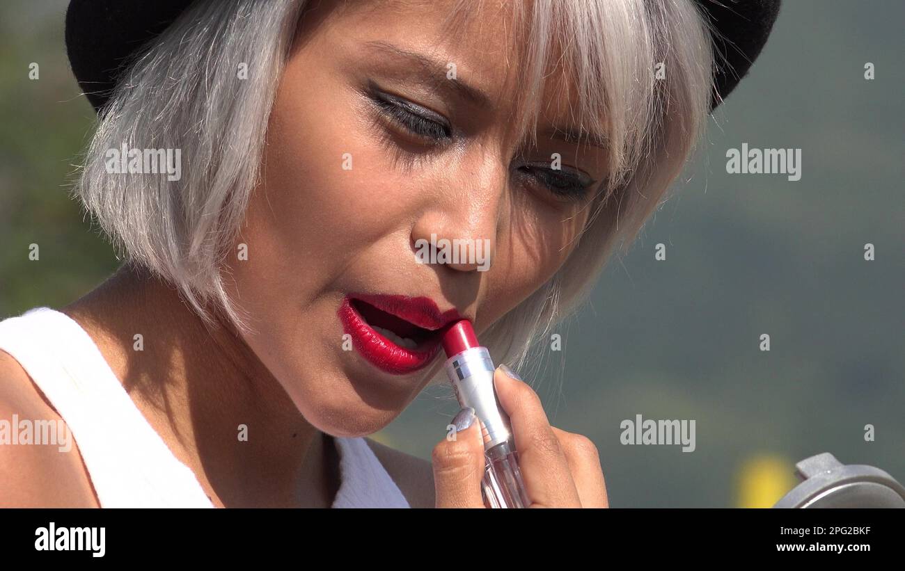 A Woman Applying Red Lipstick Stock Photo