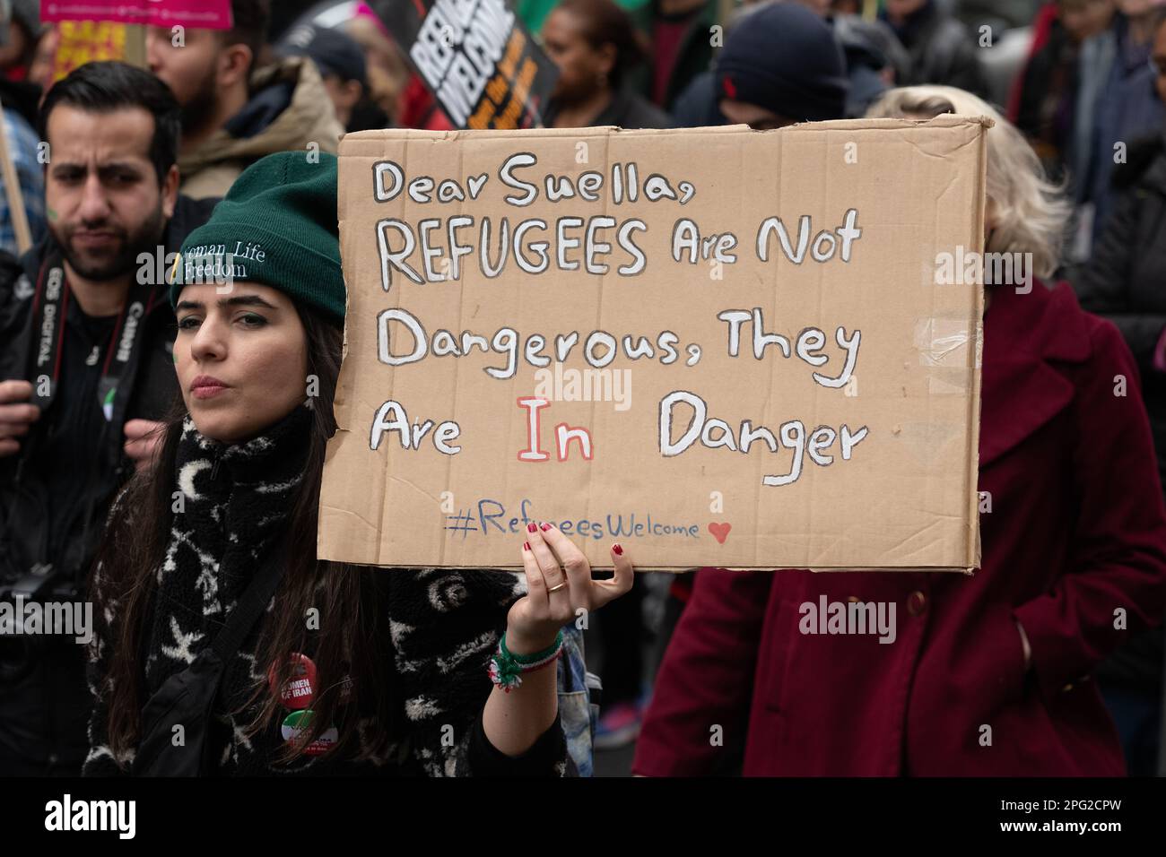 A woman holds a placard saying 'Refugees Are Not Dangerous, They Are In Danger' at the Resist Racism march marking UN Anti-racism Day,. Stock Photo