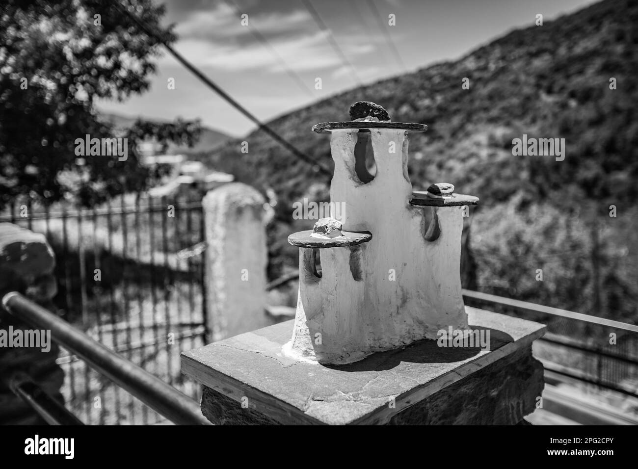 Public street fence decorations in the shapes of miniature chimneys could be seen at the village of Pampaneira, Andalusia, Spain. Black and white phot Stock Photo