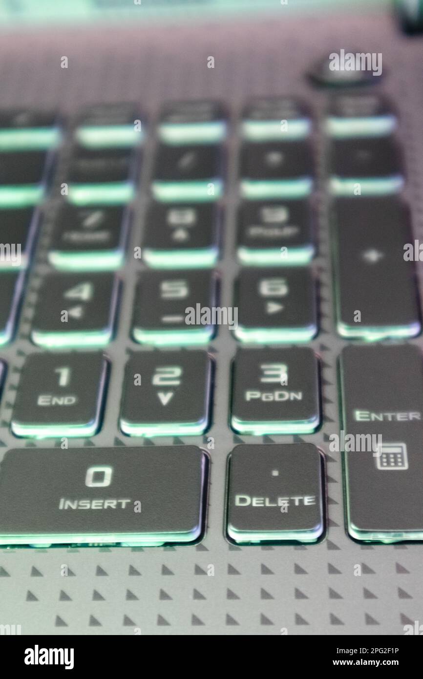 Laptop numpad keys with illumination and blurred background. Gaming grey notebook numeric keyboard close-up. Tech, IT, electronics, computer science b Stock Photo