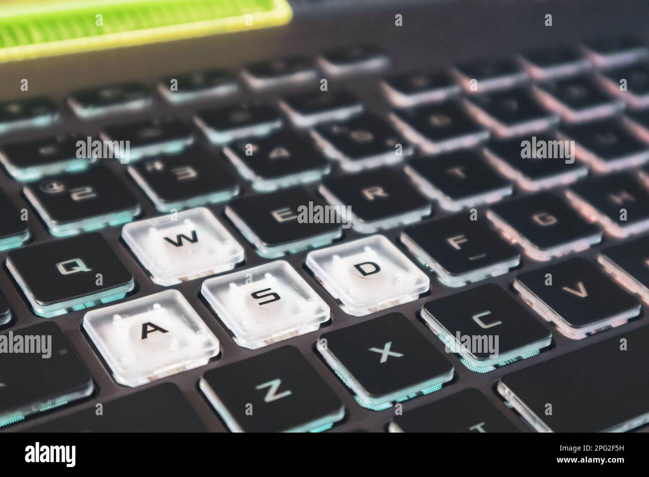 Highlighted gaming keys with focus blur. Powerful dark notebook keyboard close-up. Tech, IT, e-sport, computer science background Stock Photo