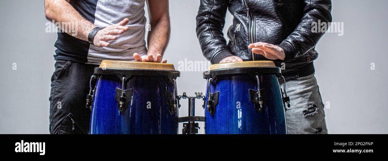 Performers playing bongo drums. Close up of musician hand playing