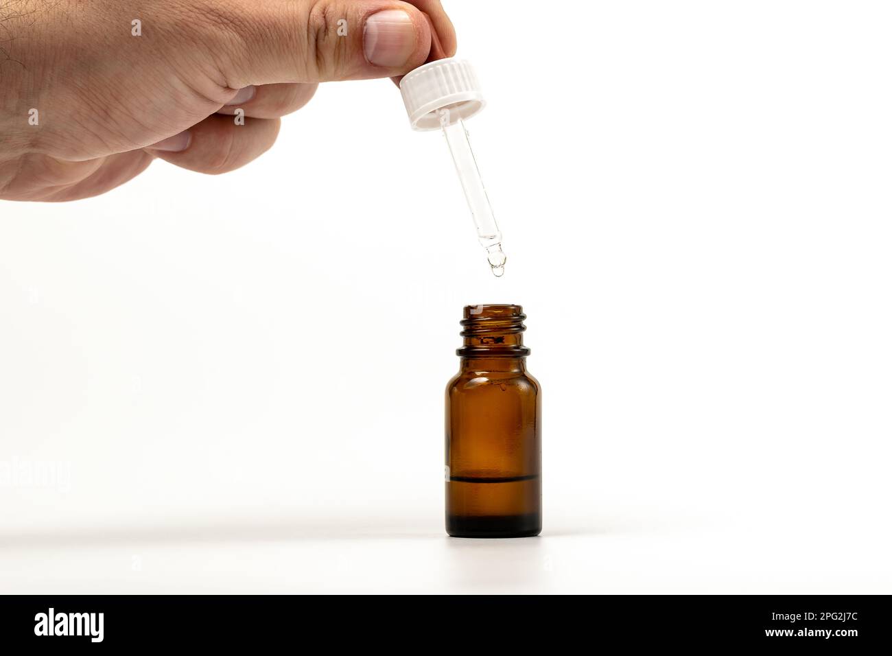Closeup photo of person dispensing medical drops vertically dripping