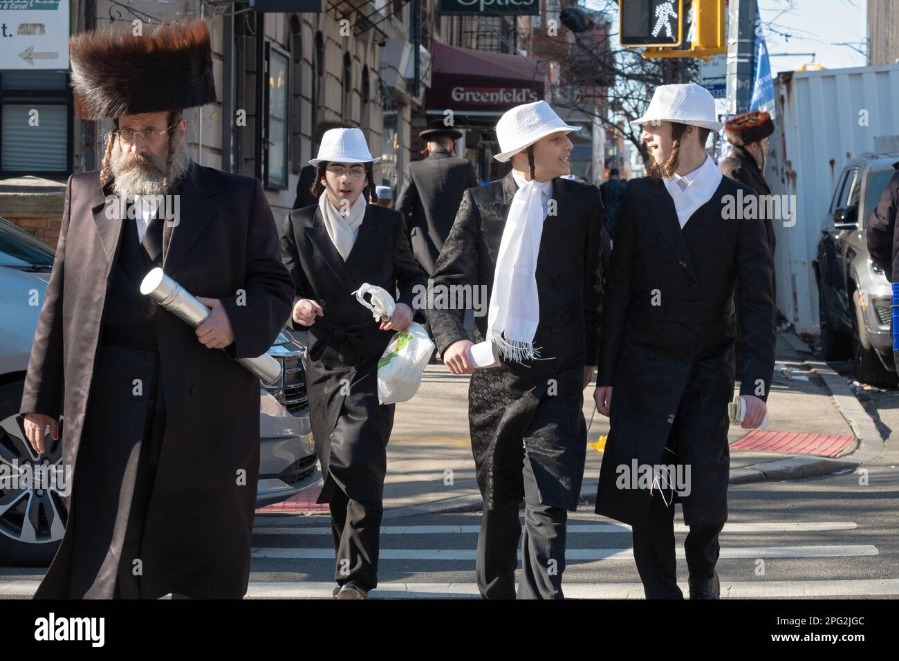 A Purim street scene in Brooklyn with a man in a shtreimal and boys in costumes. Stock Photo