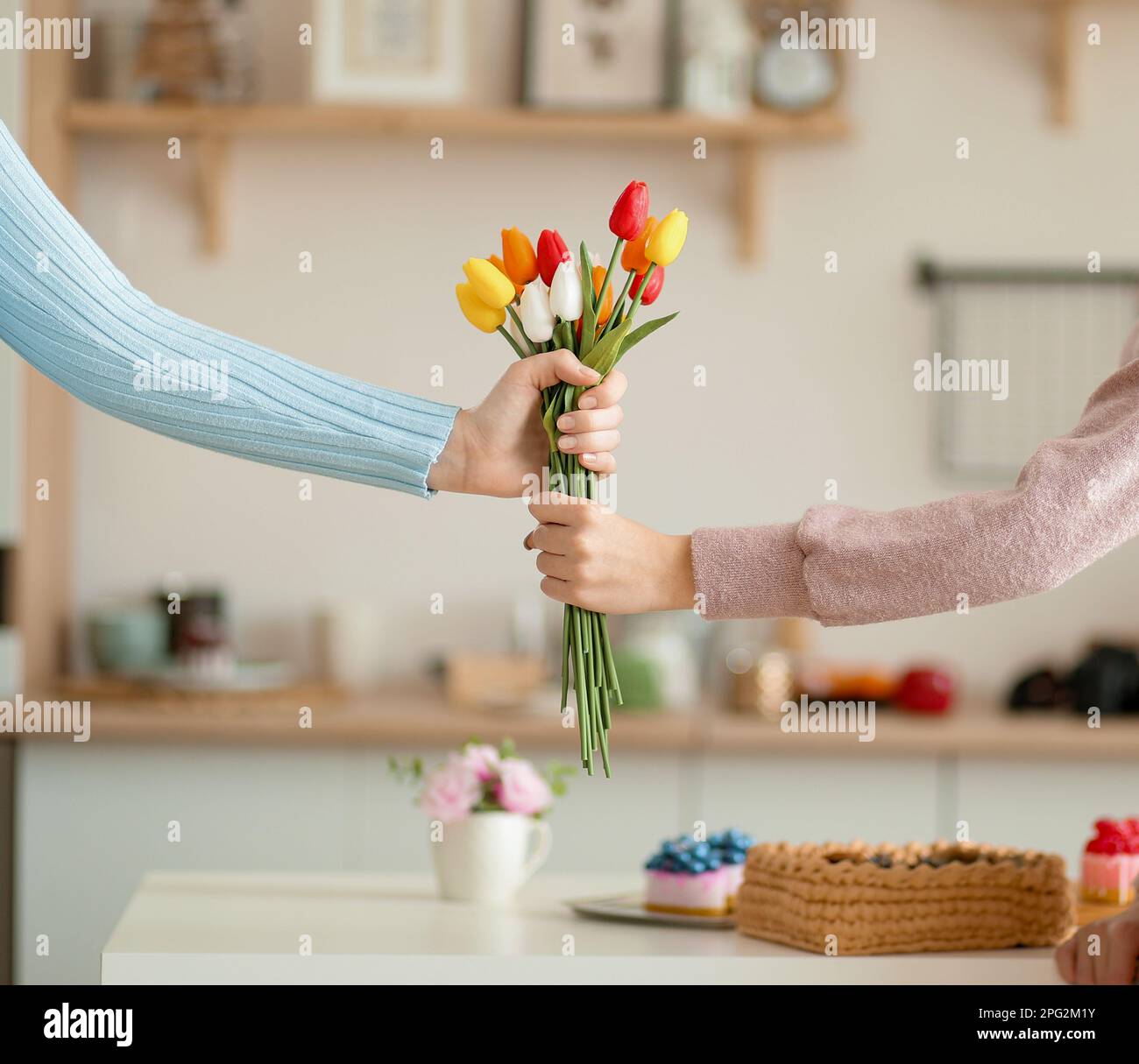 A bouquet of tulips is given to each other. Flowers in two hands on the