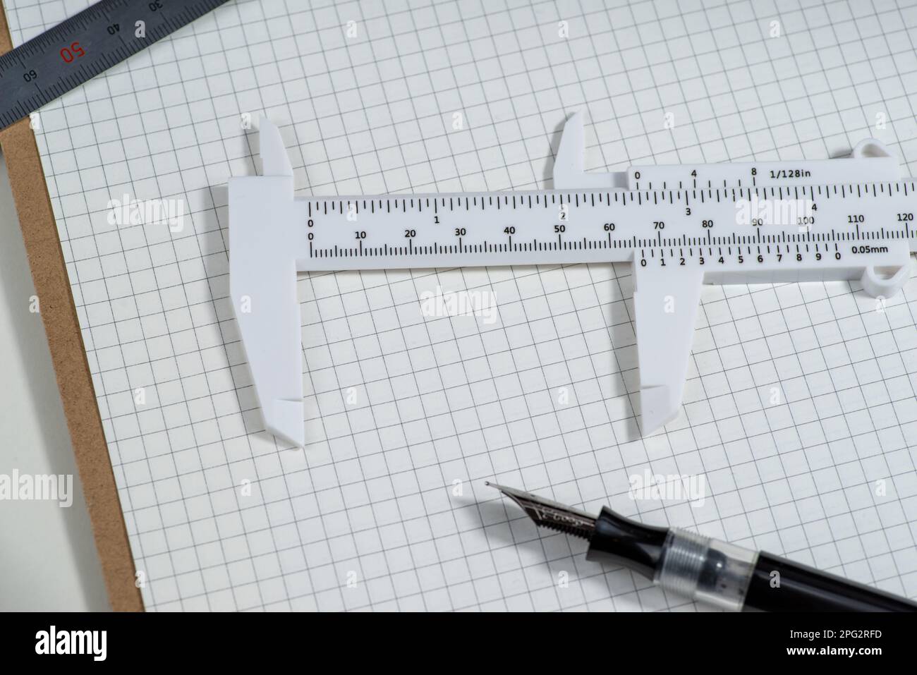 Slide calipers and handcuffs on a graph paper,copy space Stock Photo