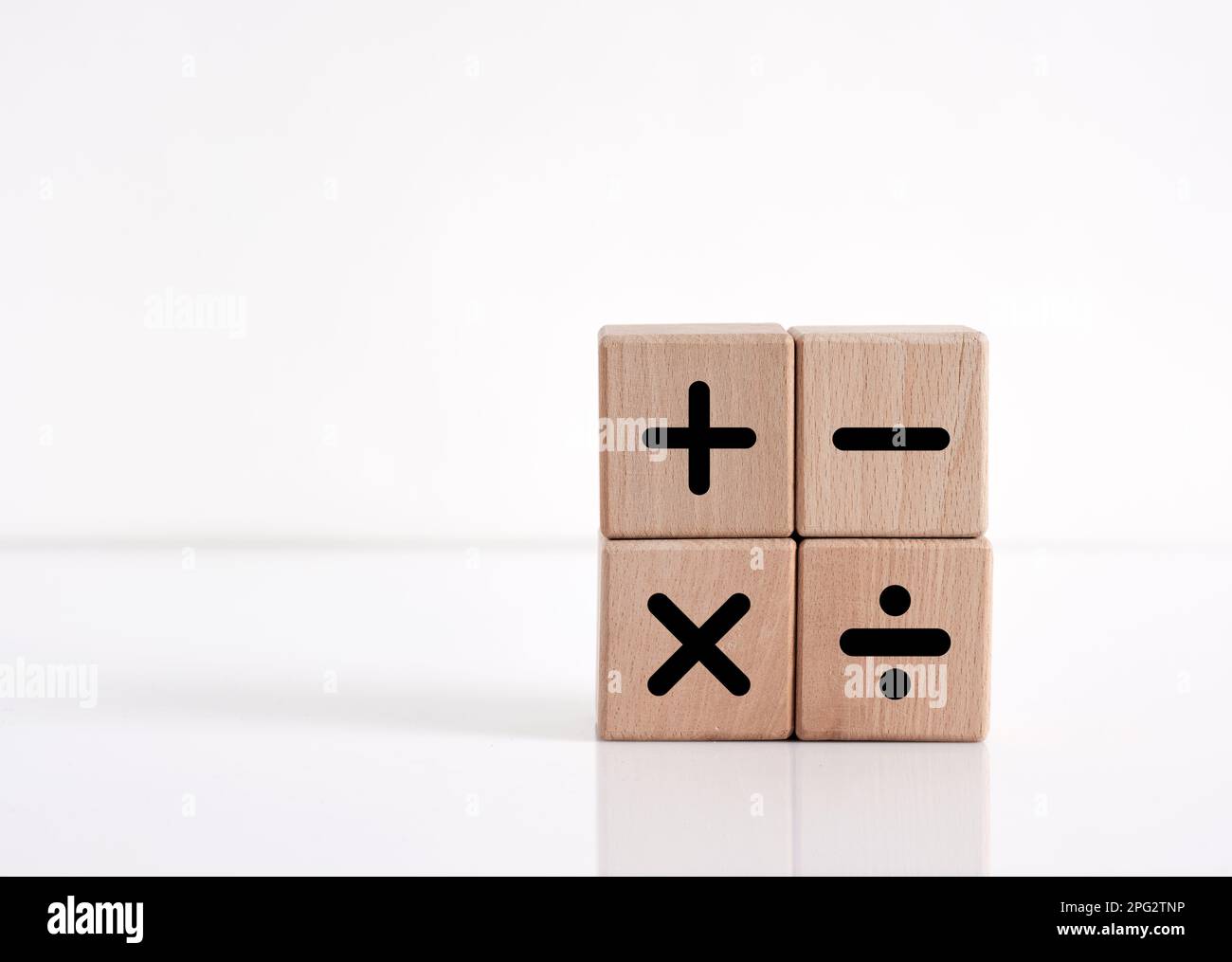 Basic mathematical operations symbols. Plus, minus, multiply and divide symbols on wooden cubes on white background. Mathematic or math education and Stock Photo