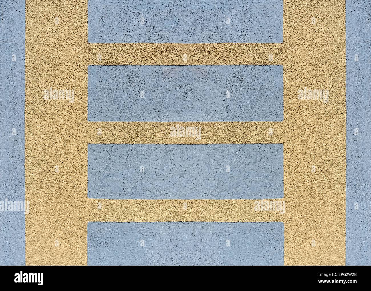 Two-tone pattern of blue rectangular areas in yellow grainy plaster Stock Photo
