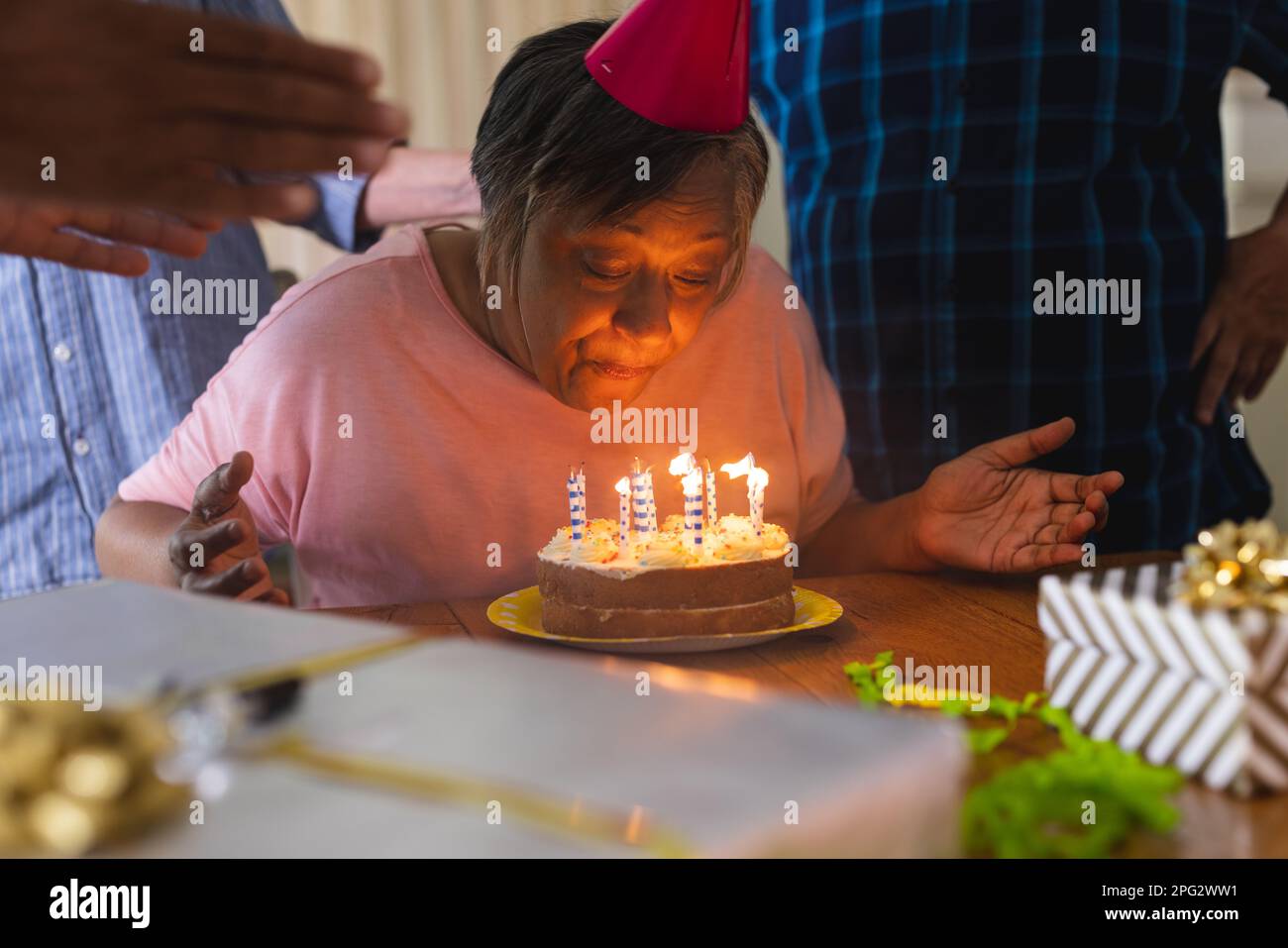 Happy group of diverse senior friends celebrating birthday with cake and presents Stock Photo