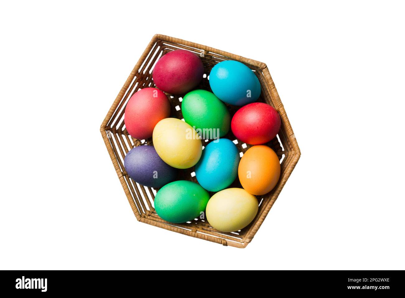 Basket of colorful Easter eggs isolated on white background. Easter basket filled with colored eggs top view holiday concept . Stock Photo