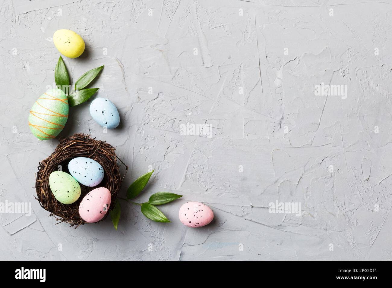 Colorful easter eggs in nest on table background with copy space top ...