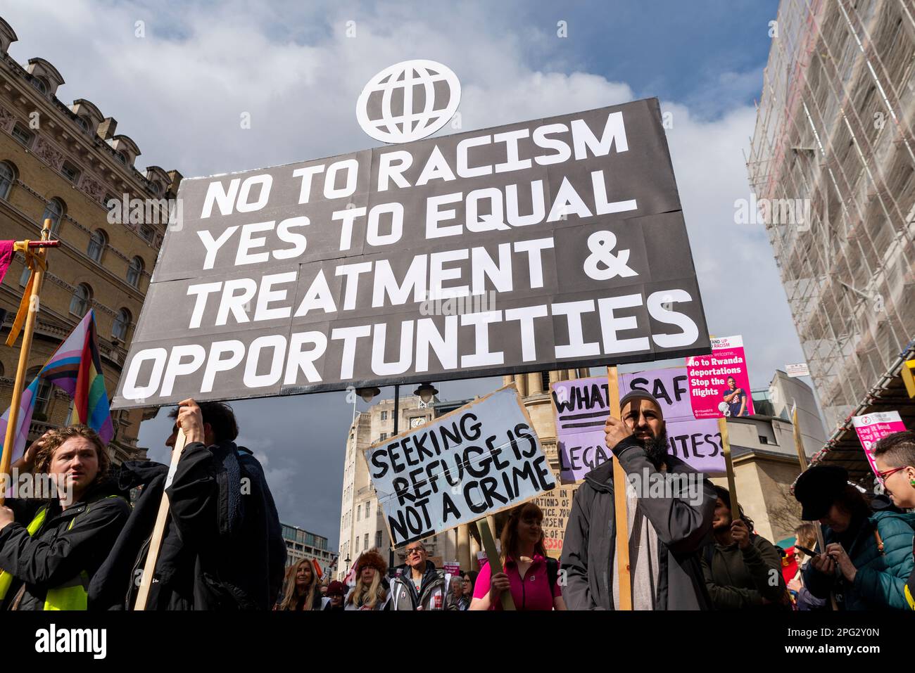 Protest taking place in London on UN Anti Racism Day. Stand up to Racism. Large placard. Equal treatment and opportunities Stock Photo