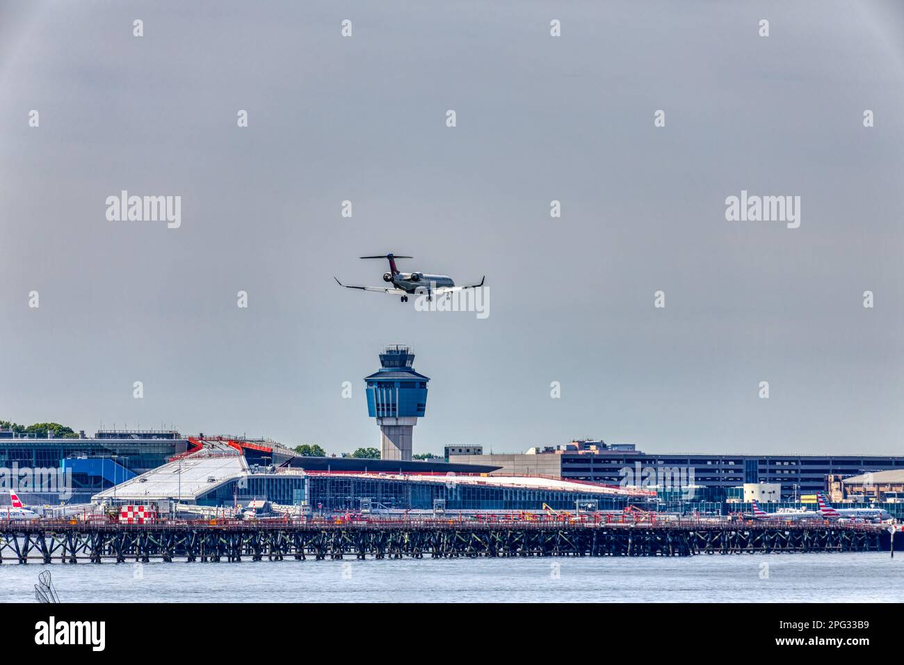 A Delta Connection Bombardier CRJ-900 twin-engine passenger jet approaches and lands at LaGuardia Airport runway 22 in East Elmhurst, Queens. Stock Photo