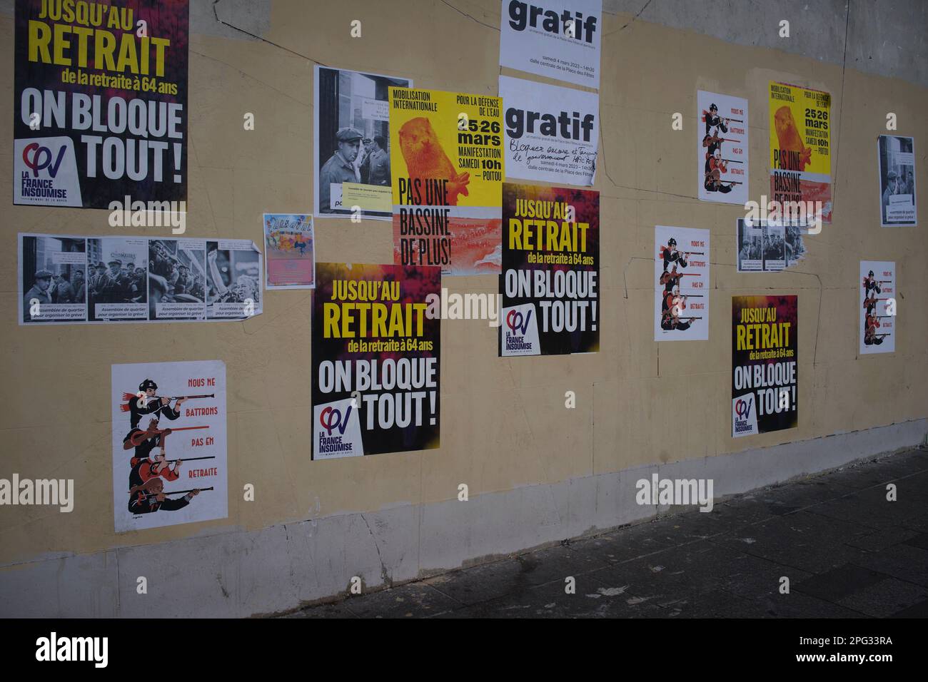 Campaign posters line a wall of Paris' Place des Fetes, as workers strike in opposition to Macron's controversial pension reforms, Place des Fêtes, 75019 Paris, France - Jane Burke, March 2023 Stock Photo