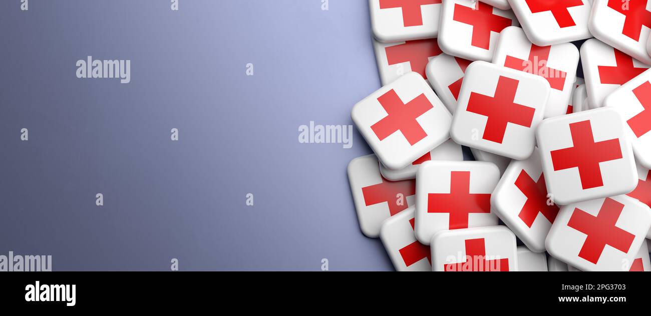 A red cross on white logo on a heap on a table. Copy space. Web banner format. Stock Photo