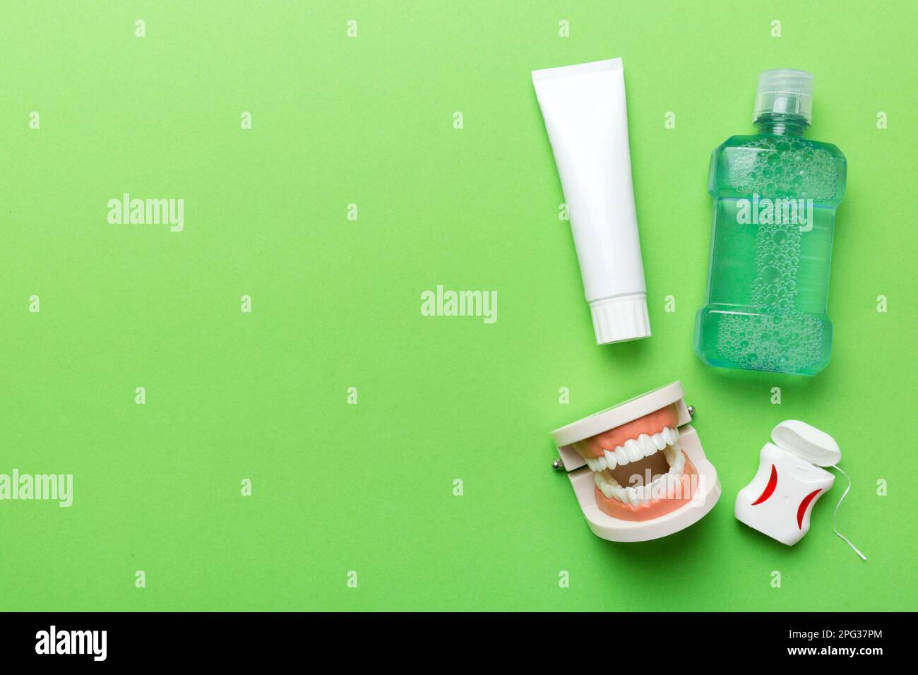 Mouthwash and other oral hygiene products on colored table top view