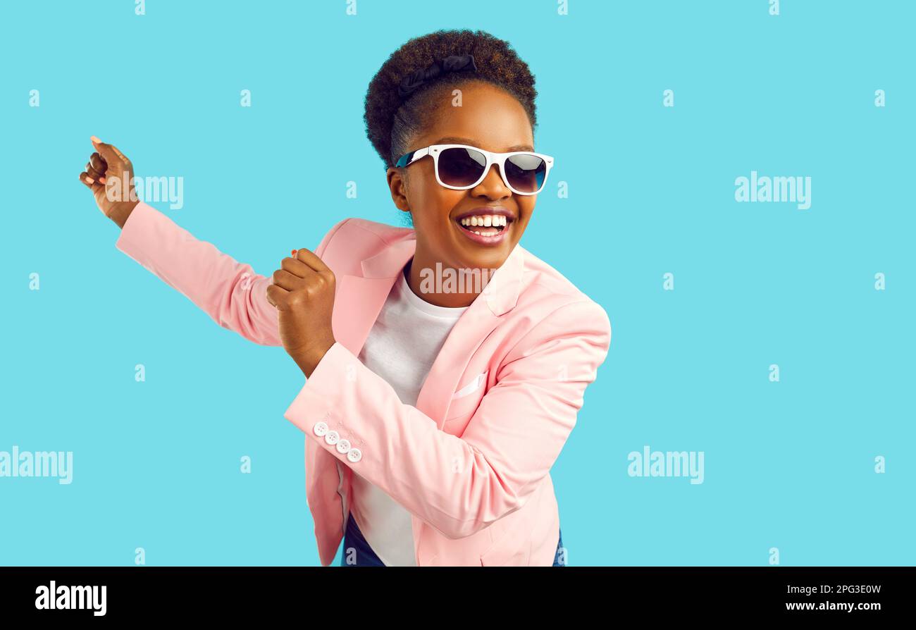 Dancing laughing african american woman in pink jacket and sunglasses