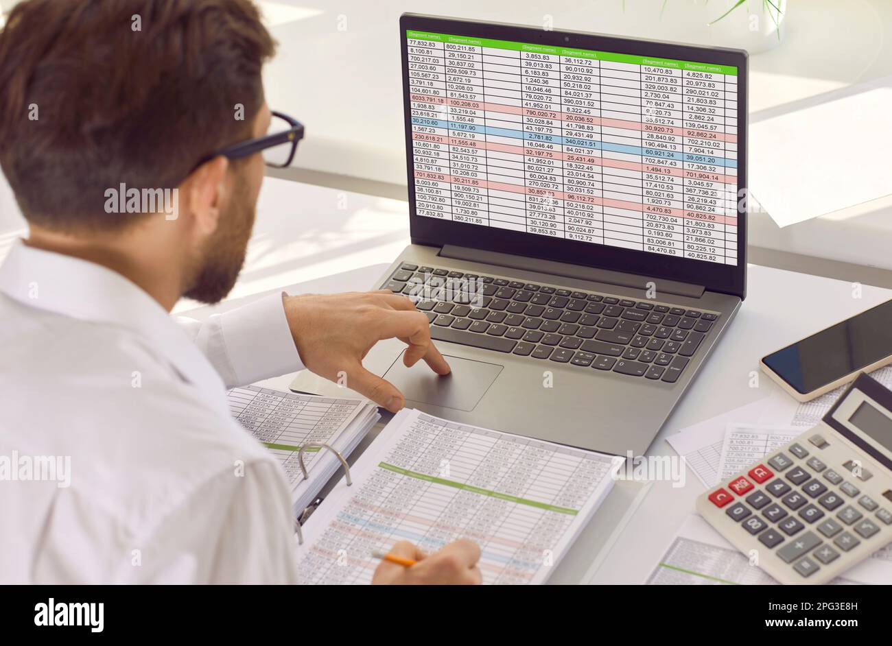 Young man analyst working with spreadsheets in office Stock Photo