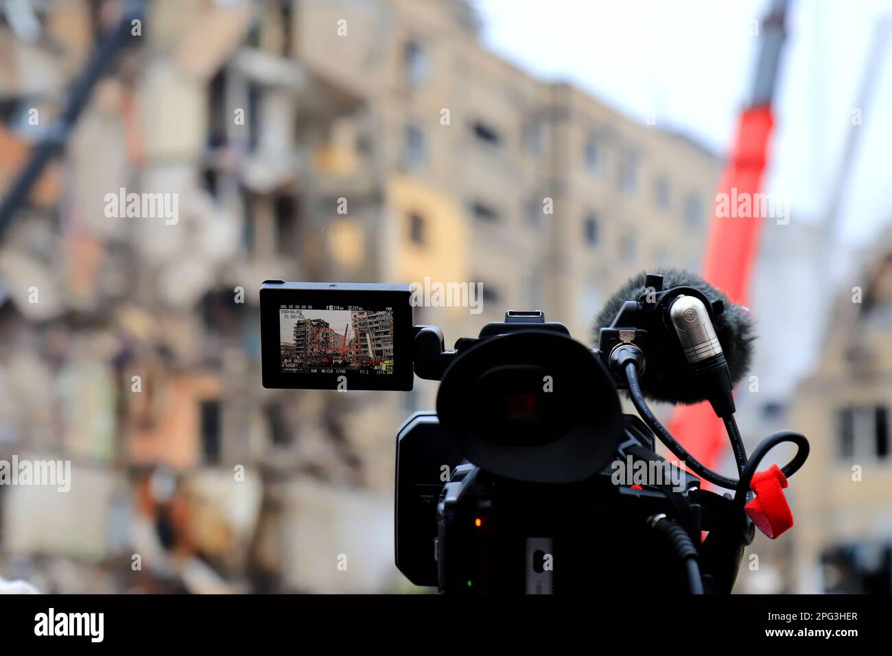 A professional TV camera broadcasts live near house destroyed by Russian rocket in city Dnipro. Live broadcast of Reuters news agency. Russia war agai Stock Photo