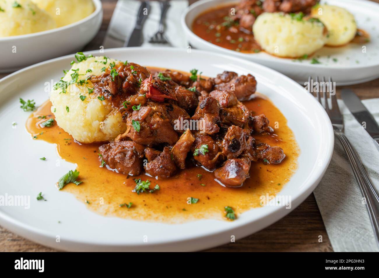 Meat dish with potato dumplings on a plate Stock Photo