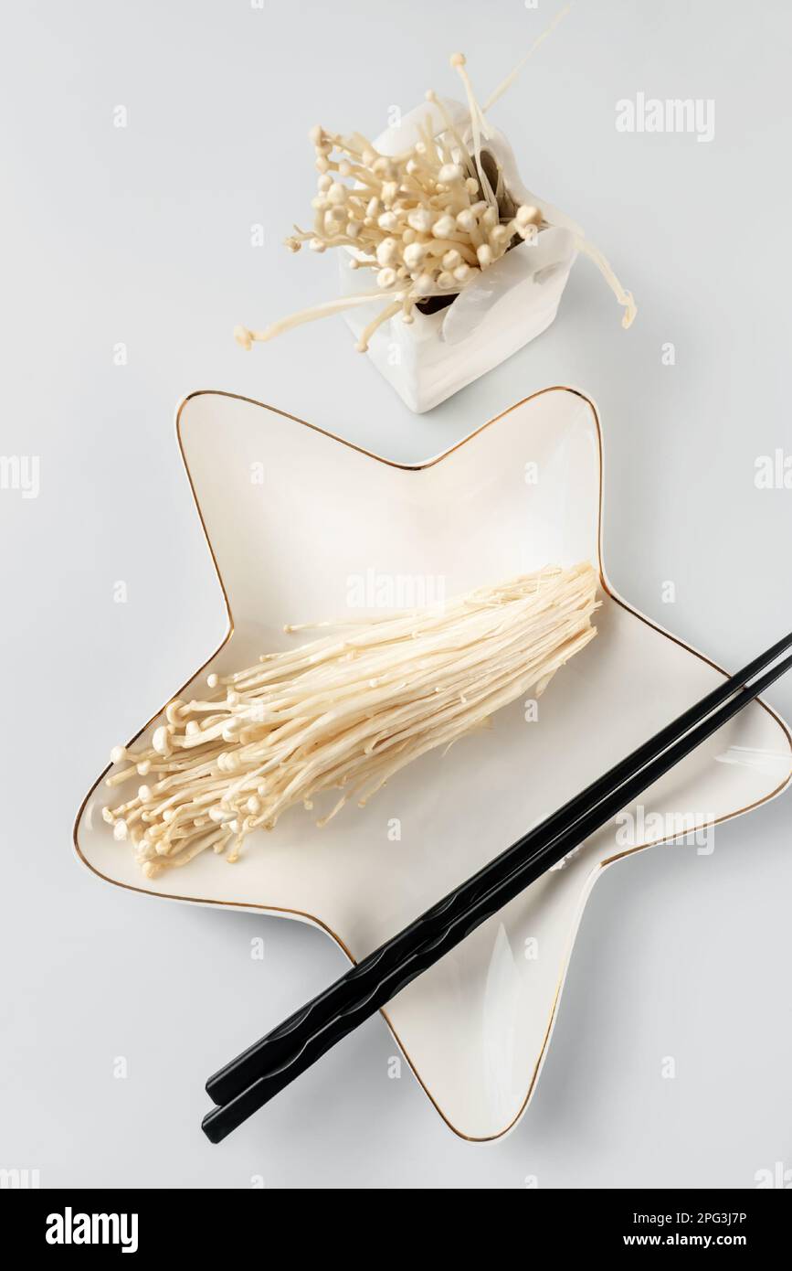 fresh enoki mushrooms or golden needle mushrooms on a star-shaped plate ...
