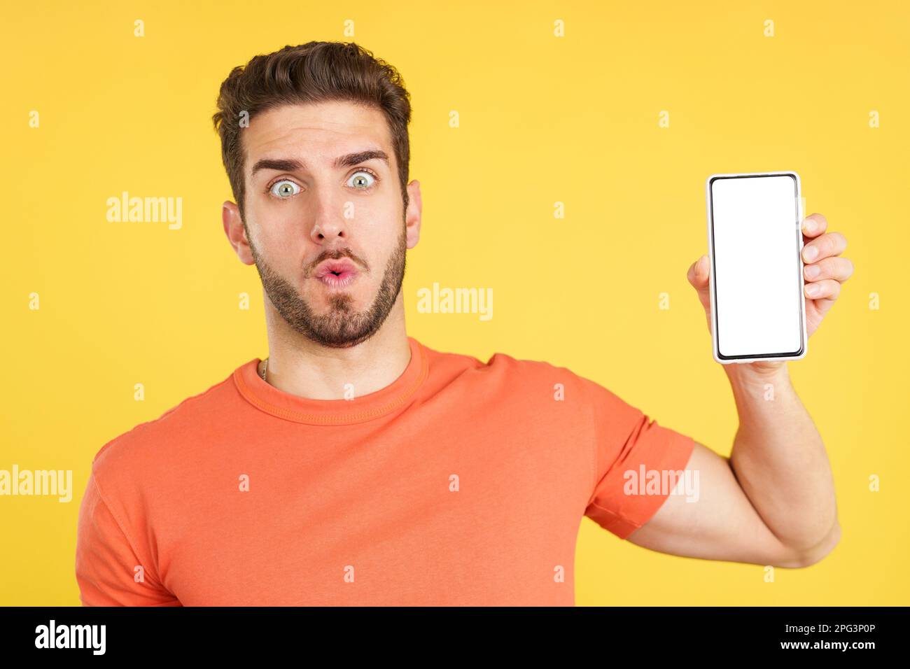 Surprised caucasian man holding a mobile with a blank screen Stock Photo