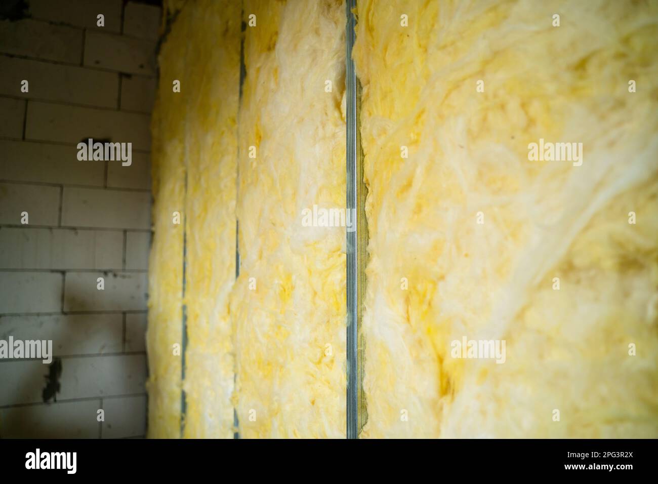 The partition is filled with glass wool. Frame wall from a metal profile with mineral wool close-up. Freshly built interior partition in a private hou Stock Photo
