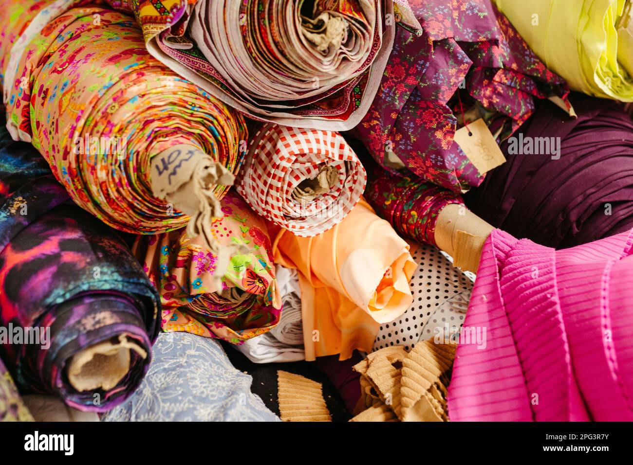 A vibrant collection of multicolored fabric rolls and swatches ...