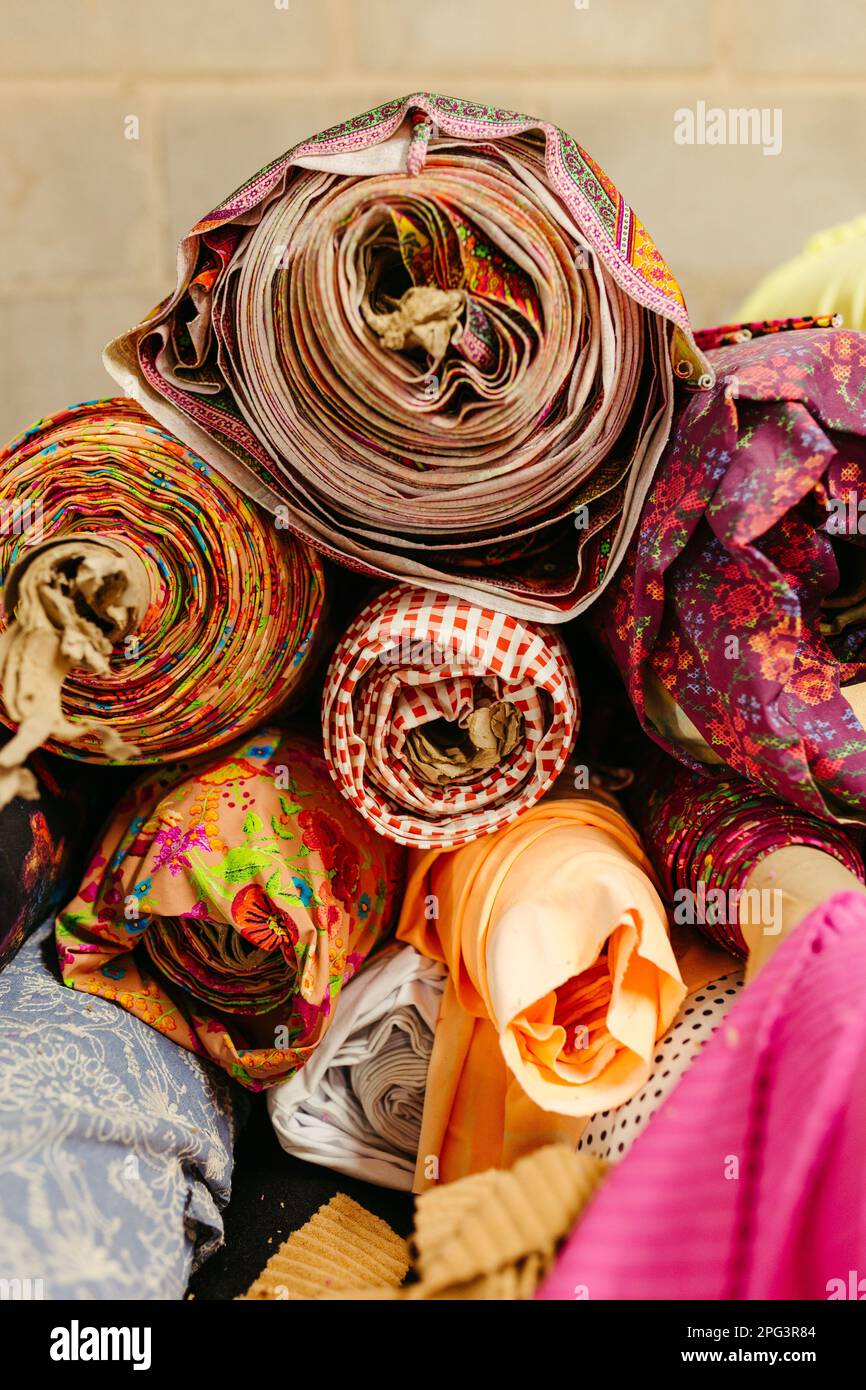 A vibrant collection of multicolored fabric rolls and swatches ...