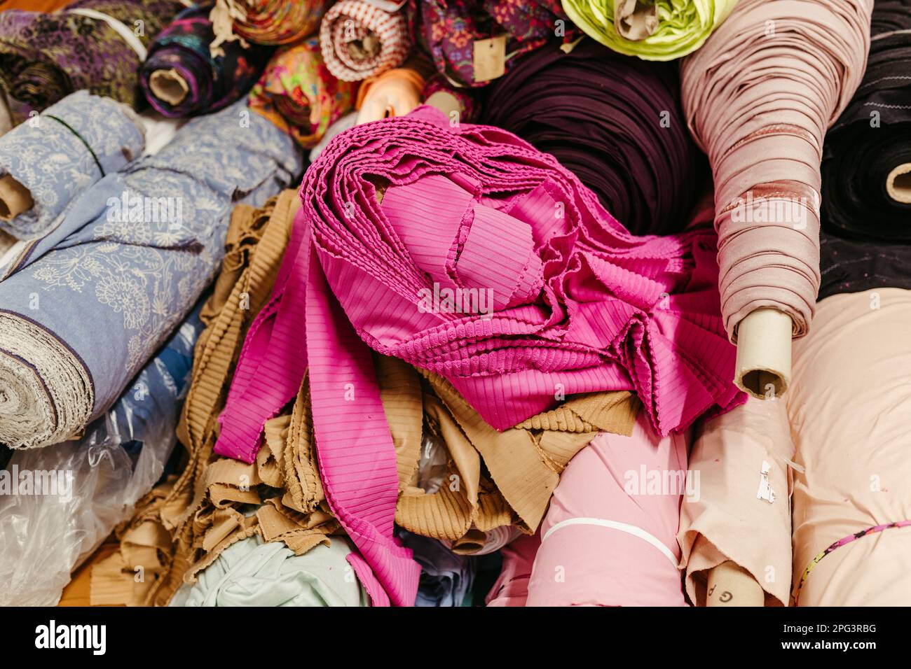 A vibrant collection of multicolored fabric rolls and swatches ...