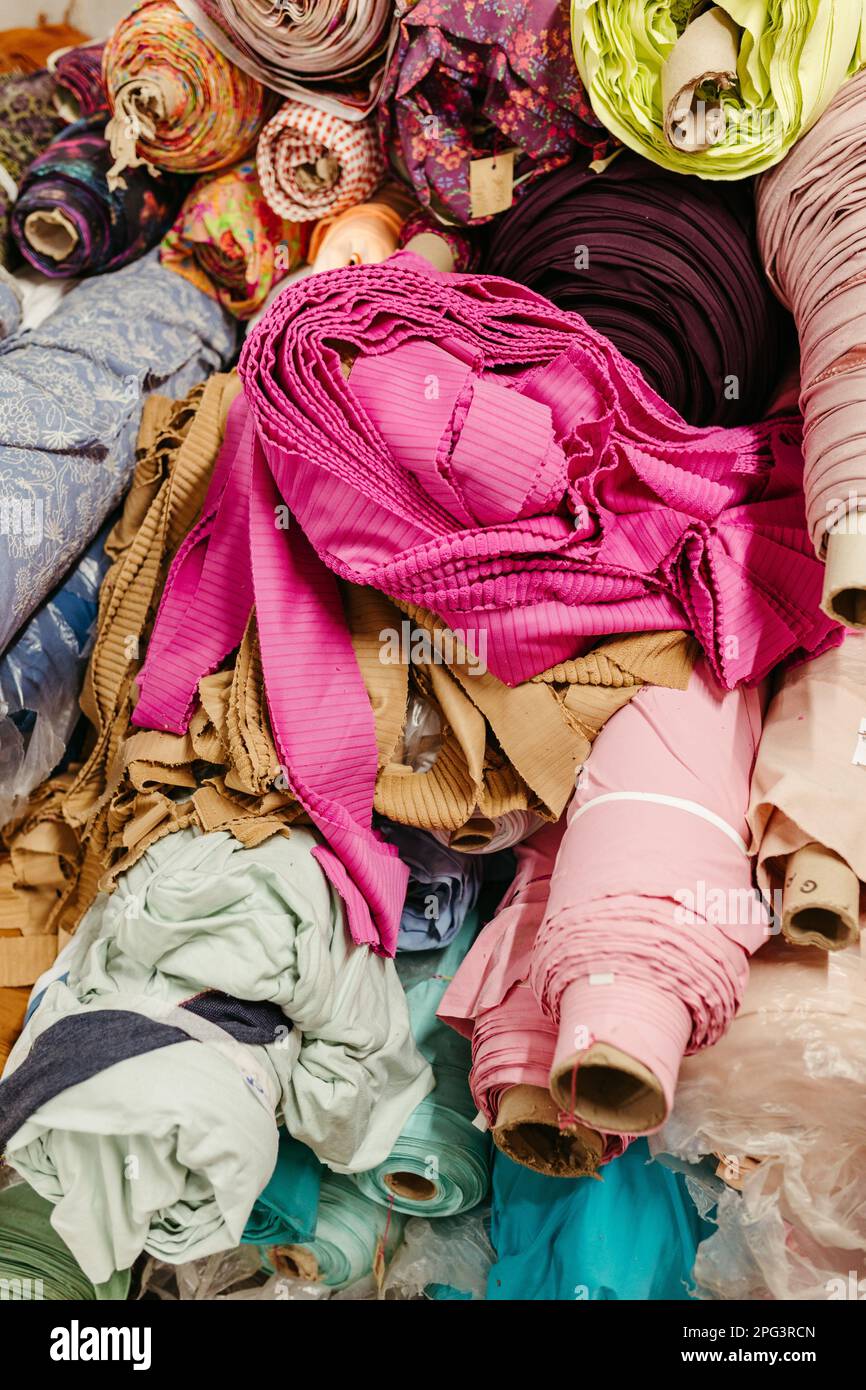 A vibrant collection of multicolored fabric rolls and swatches ...