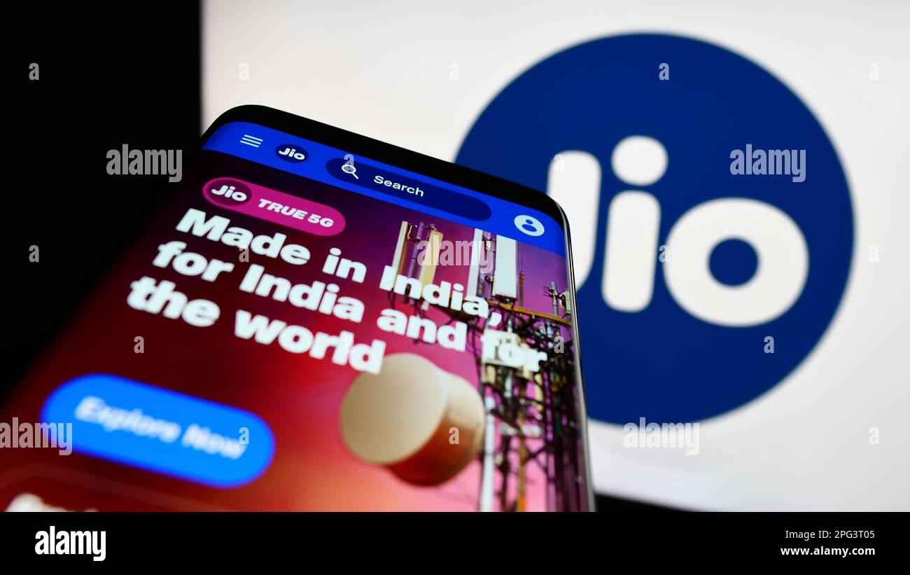 Smartphone with website of Indian telecommunications company Reliance Jio on screen in front of business logo. Focus on top-left of phone display. Stock Photo