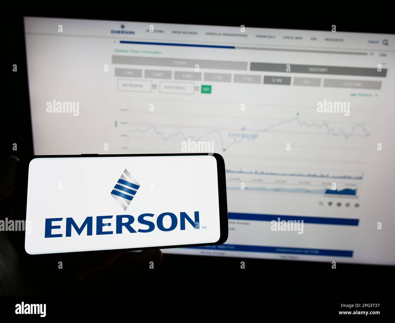 Person holding mobile phone with logo of american company emerson