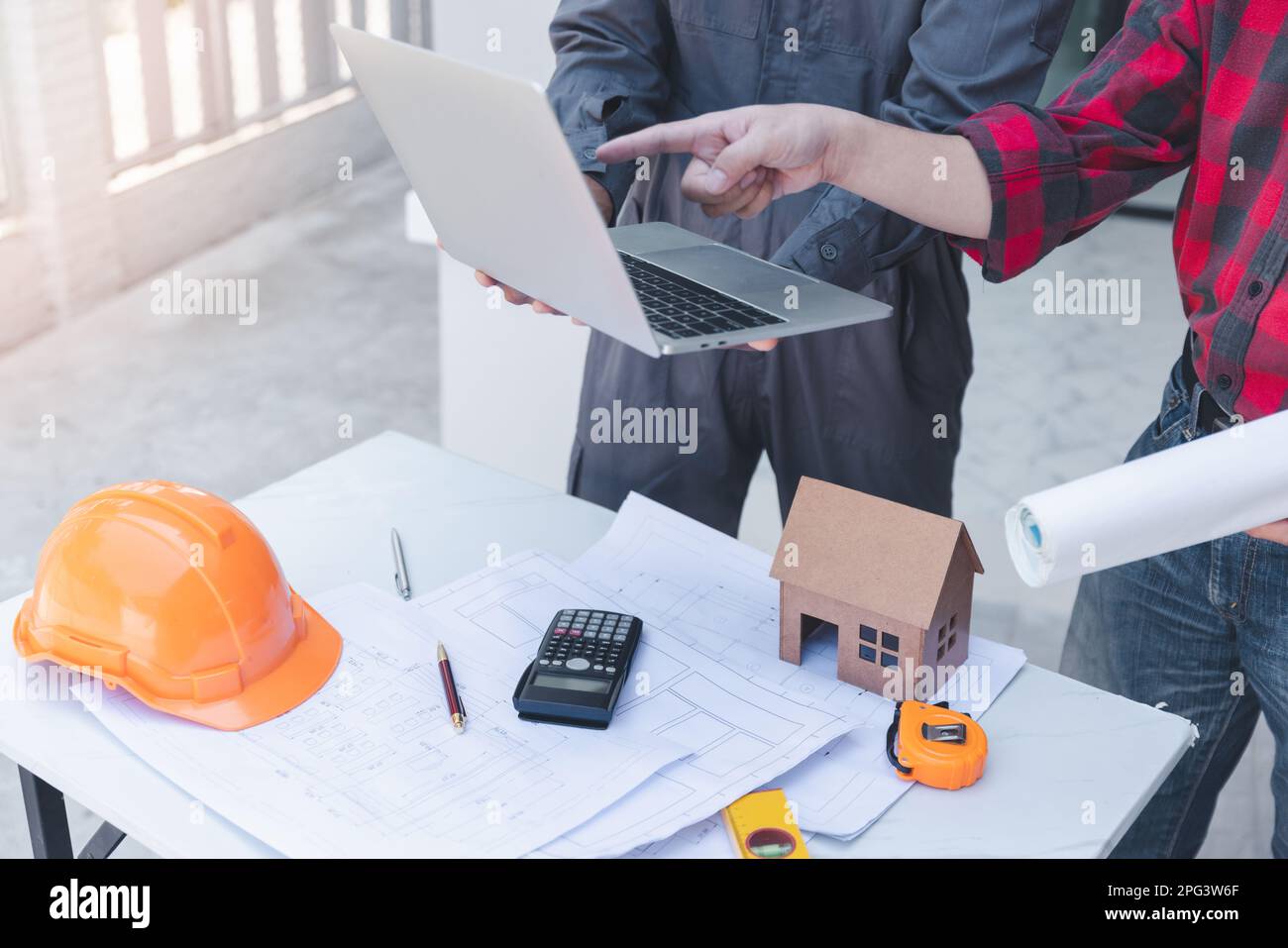 Construction concept of Engineer and Architect working at Construction Site with blue print, Engineer and Architect discussing construction plan with Stock Photo