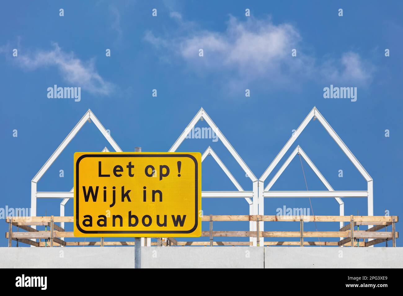Sign with the Dutch text for 'Attention - Residential area under construction' in front of new family homes in The Netherlands Stock Photo