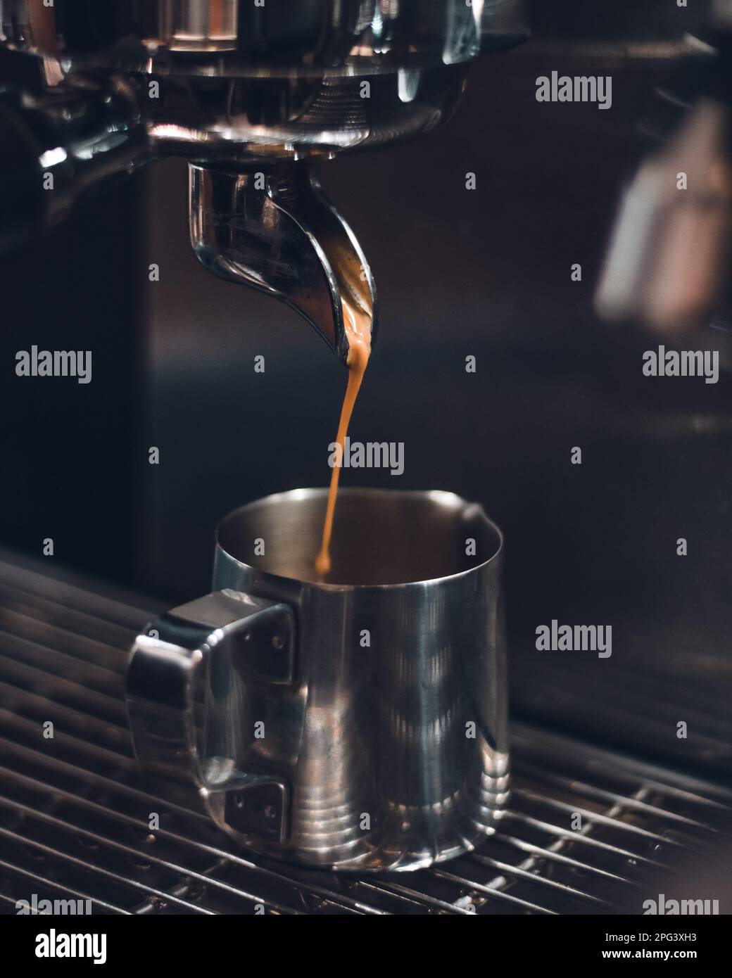 A freshly brewed coffee steaming and dripping from the espresso machine