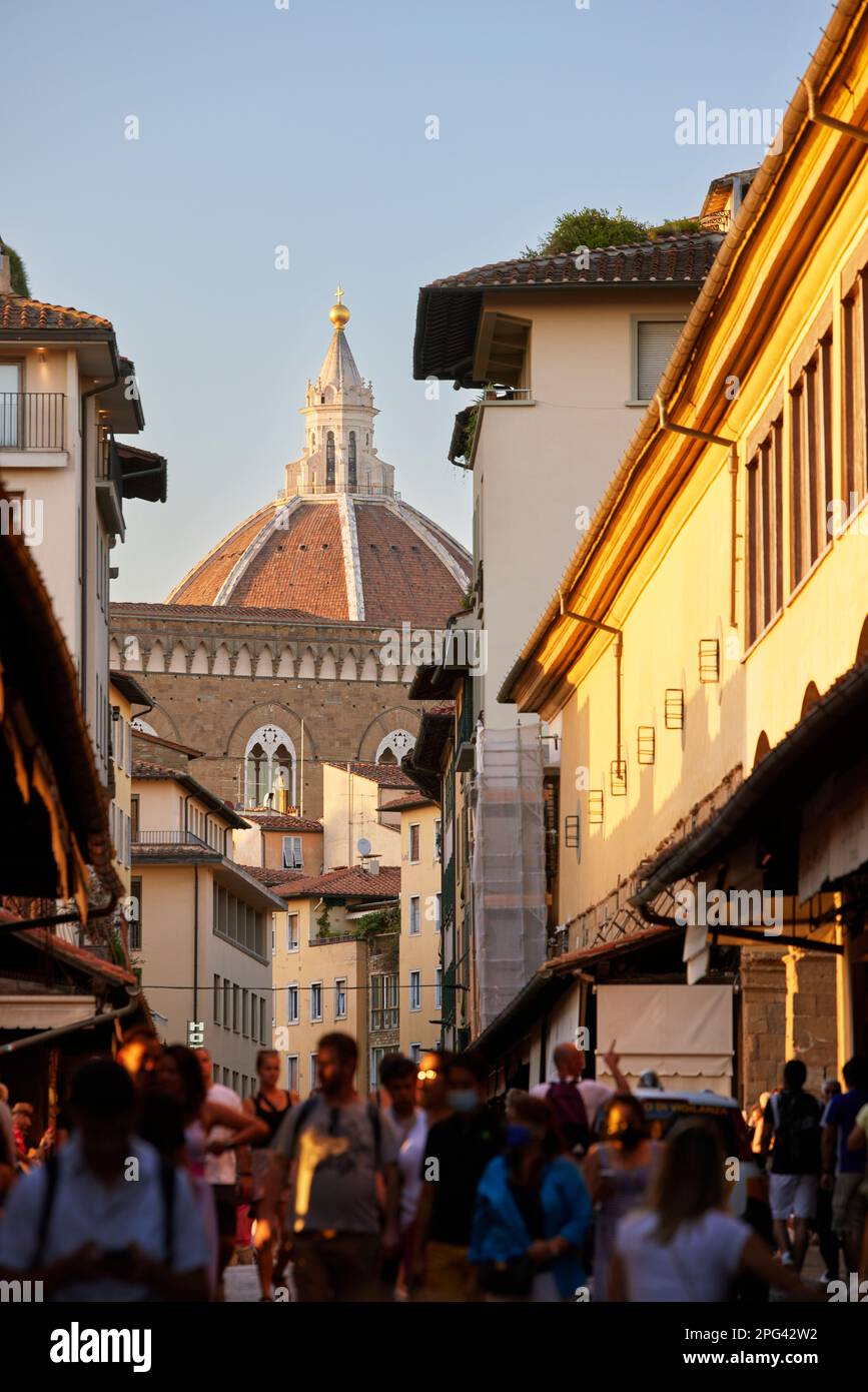People walking over Ponte Vecchio, Duomo in background, Florence, Italy Stock Photo
