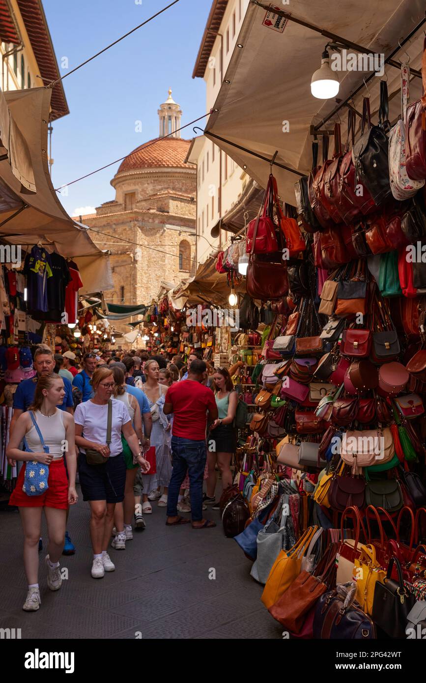 People looking at handbags, in street market outside Mercato Centrale, Basilica di San Lorenzo in background, Florence, Tuscany Stock Photo