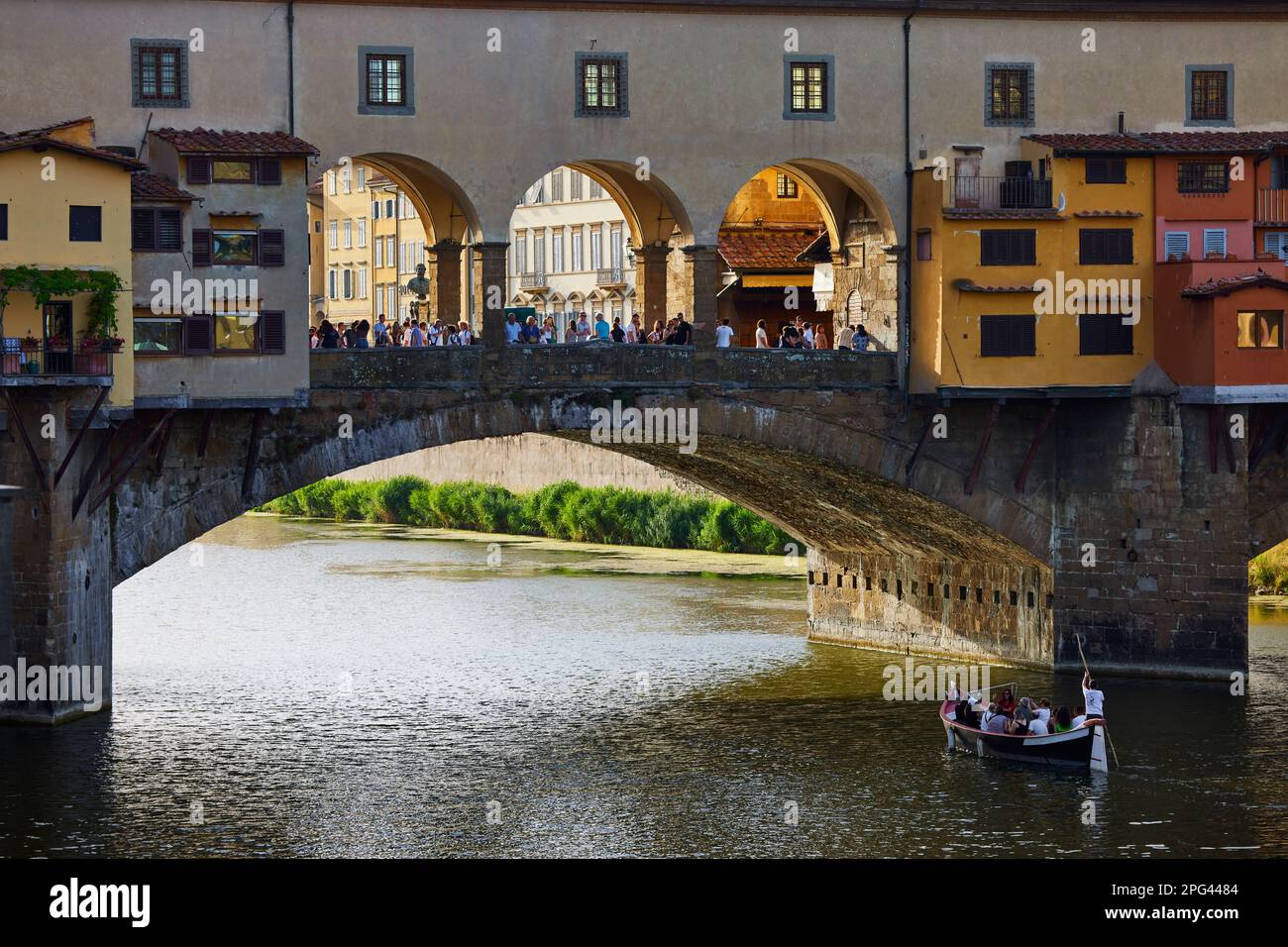 Tourist gondola passing under arch of Ponte Vecchio, Florence, Italy Stock Photo