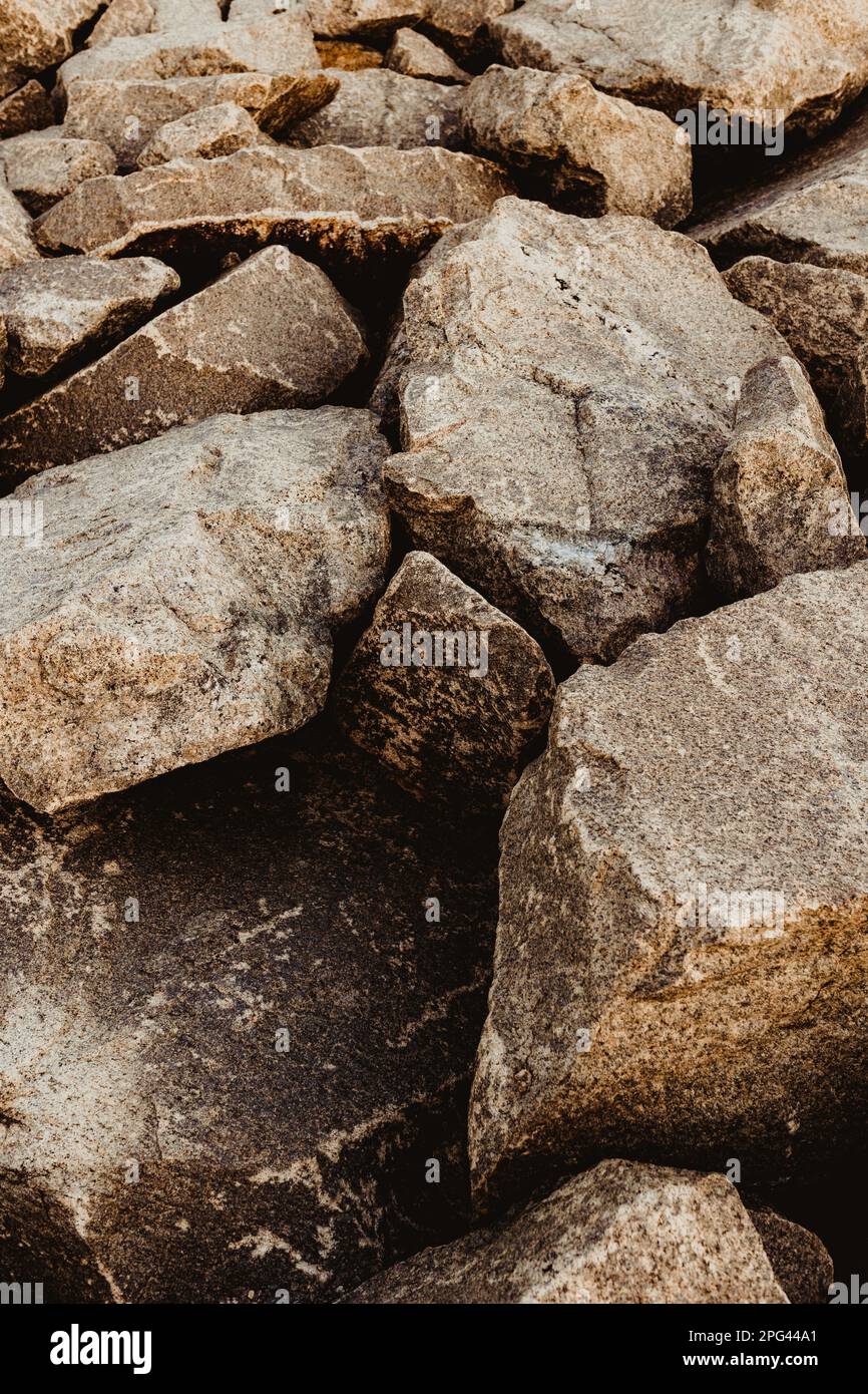 A vertical shot of massive rocks on the beach, perfect for wallpapers ...