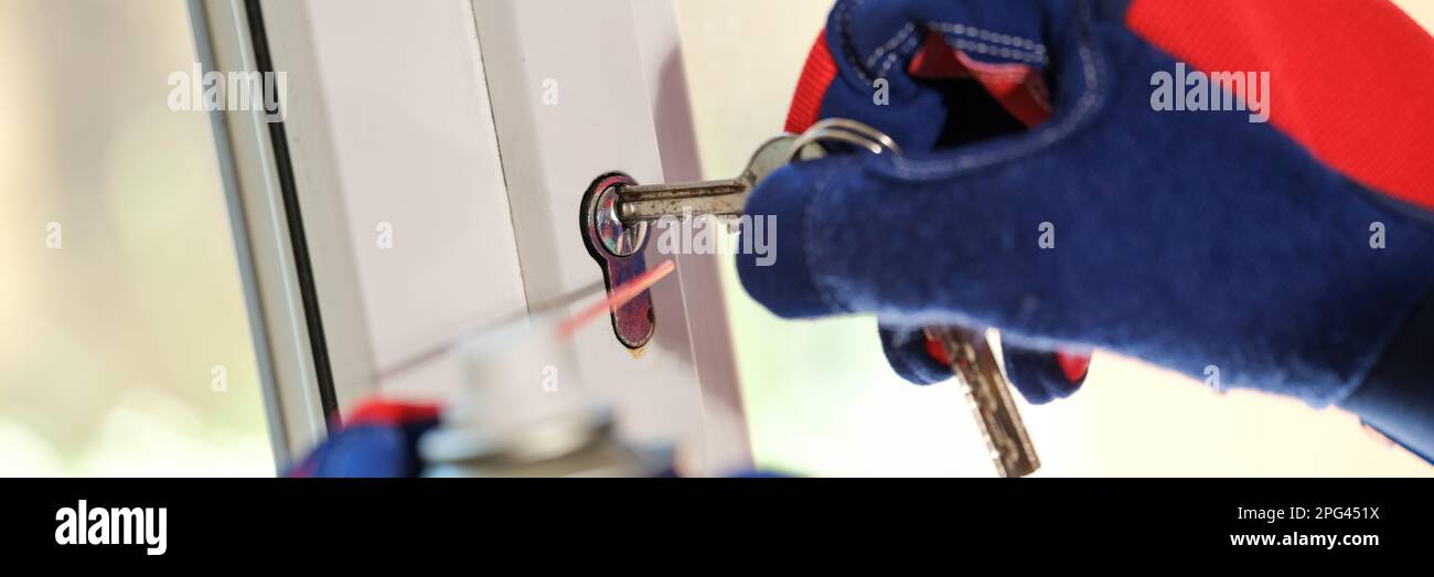 Window master repairing lock on key on window frame Stock Photo