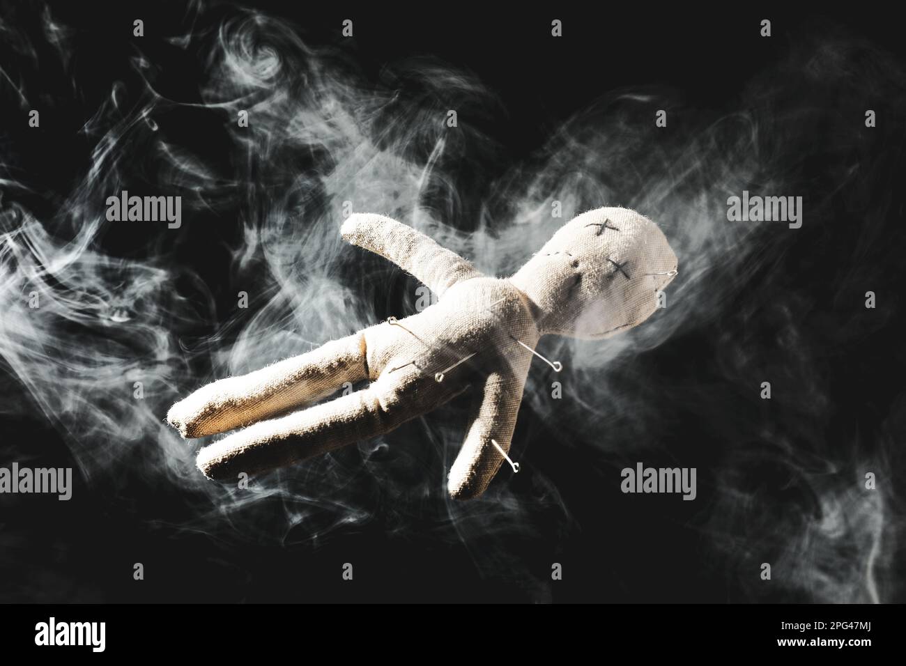 Voodoo doll with pins and smoke on dark background Stock Photo - Alamy