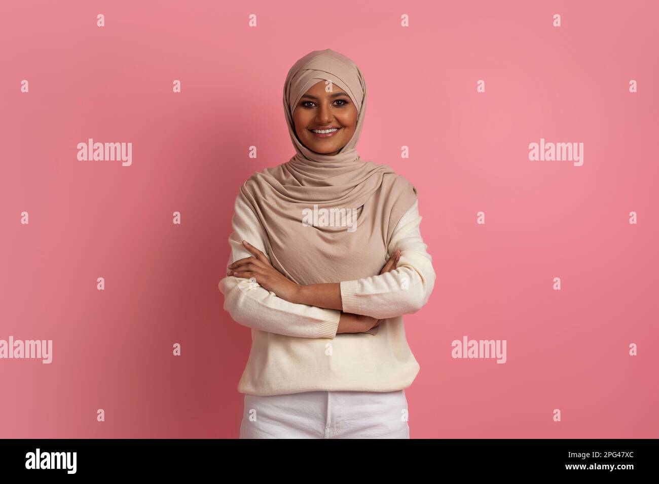 Portrait Of Confident Young Muslim Woman In Hijab Posing With Folded Arms Stock Photo