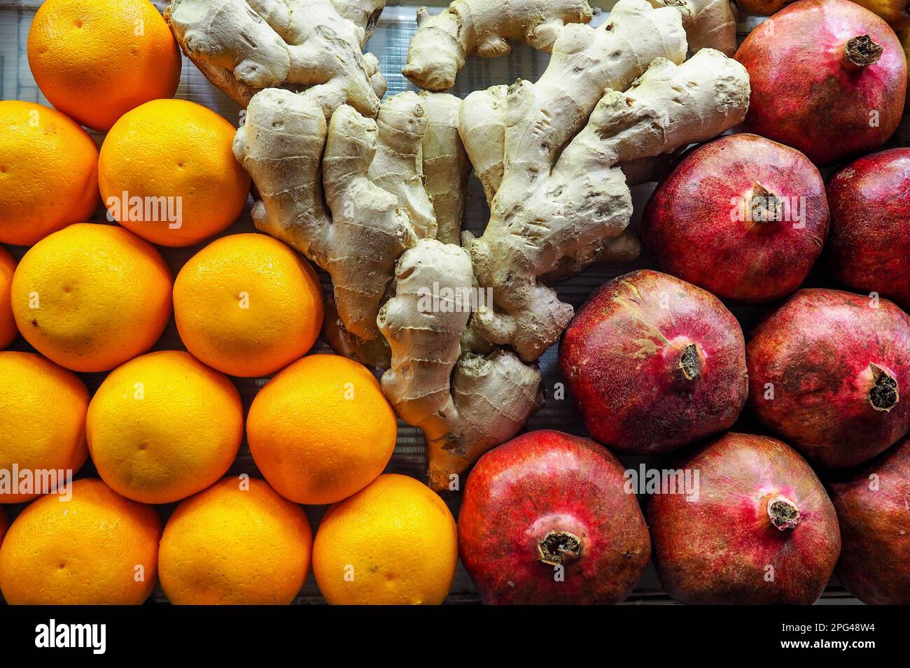 Oranges, ginger and pomegranate displayed at street market in Morocco, closeup detail Stock Photo