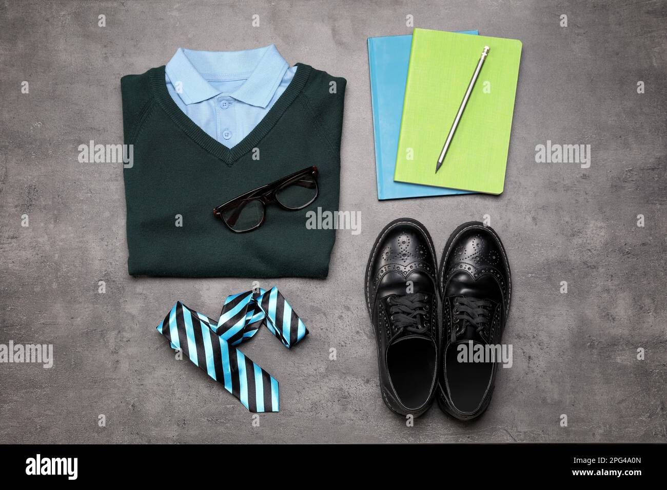 Stylish school uniform for boy and stationery on grey background, flat lay Stock Photo