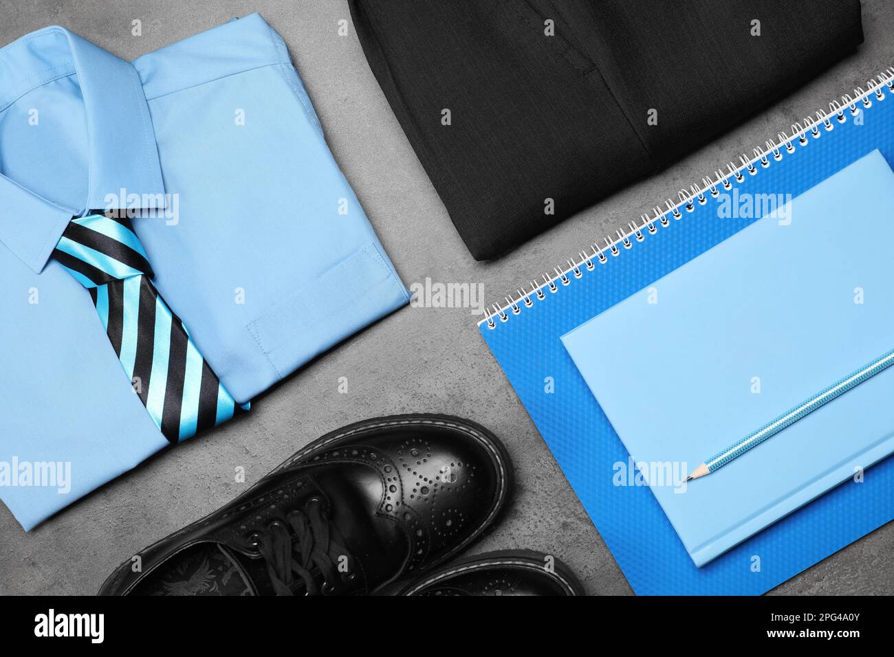 Stylish school uniform for boy and stationery on grey background, flat lay Stock Photo