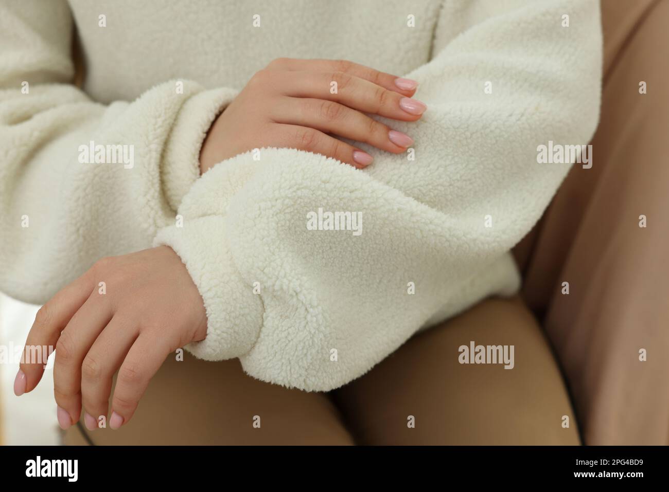 Woman touching sweater made of soft white fabric, closeup Stock Photo