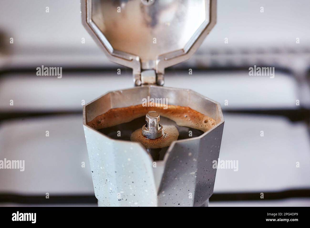 A geyser coffee maker on a gas stove produces a portion of coffee Stock