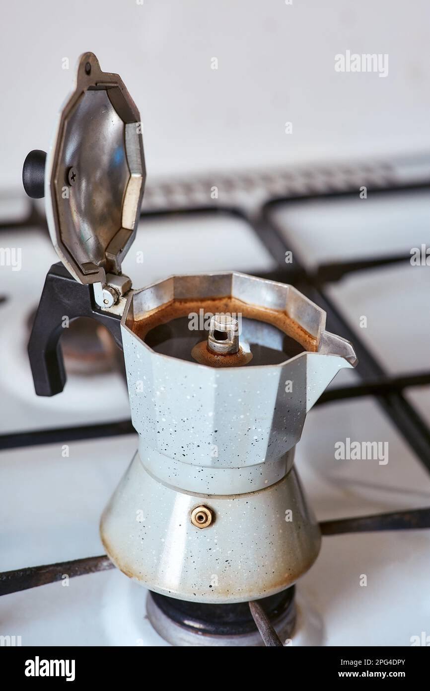 A geyser coffee maker on a gas stove produces a portion of coffee Stock